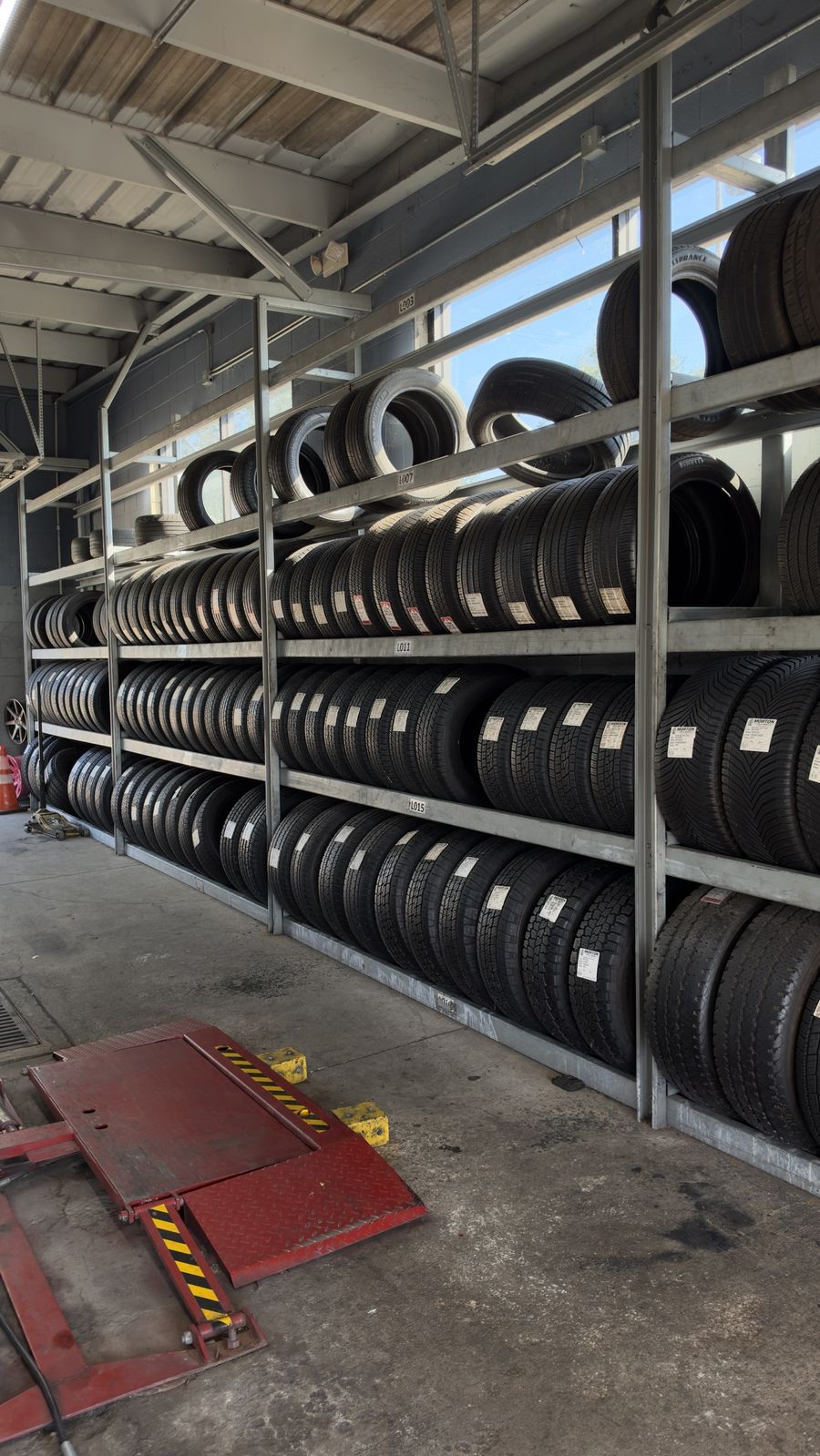 Rack de llantas usadas inspeccionadas con etiquetas de MTW en Morton Tire and Wheels, Katy, TX